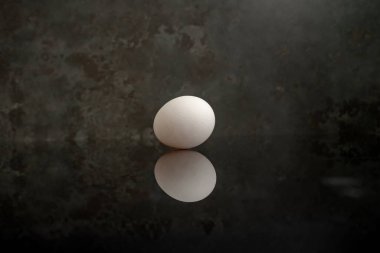 Taze yumurtayı kapat, pürüzsüz yüzeyini, doğal dokusunu ve ince kıvrımlarını vurgula. Mutfak ya da yemek fotoğrafçılığı için mükemmel.