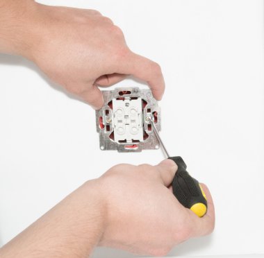 Bir tornavida ile bir elektrik anahtarı yükleme