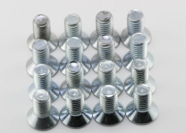 Many bolts in a row on a white background — Stock Photo, Image