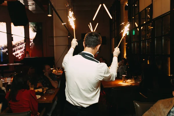 带着烟花的侍者在餐馆祝贺生日客人的后视镜 — 图库照片
