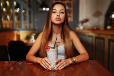 Seksi kadın tatlı milkshake içiyor.