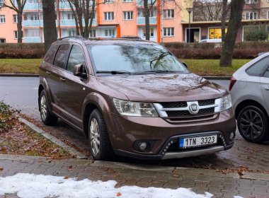 Ostrava, Çek Cumhuriyeti - 8 Ocak 2025: Kahverengi Fiat Freemont SUV veya kışın sokağa park edilmiş Dodge Journey temelli MPV otomobil