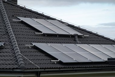 Yeşil yenilenebilir enerji üretmek için güneş panelleri olan gri çatı