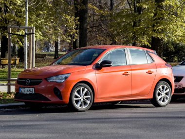 Ostrava, Çek Cumhuriyeti - 25 Kasım 2024: Kırmızı Opel Corsa F küçük hatchback caddeye park edilmiş, ön üç çeyrek manzara