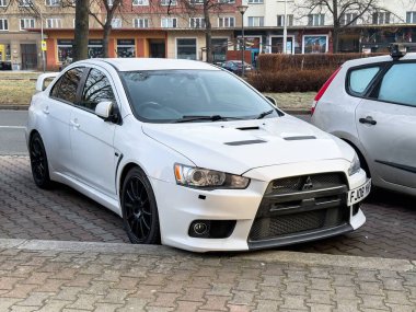 Ostrava, Çek Cumhuriyeti - 4 Mart 2025: Beyaz Mitsubishi Lancer Evo X spor arabası caddeye park edildi