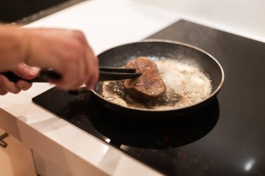 Biberiyeli ve tereyağlı tavada biftek pişirme süreci.