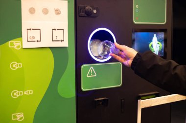 İnsan eli makineye plastik şişe koyar. Müşteriler biberonlarını ve kutularını geri veriyorlar. Yüksek kalite fotoğraf