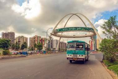 Ünlü şehir simgesi Biswa Bangla Kapısı sanat galerisi. Kolkata 'nın Rajarhat bölgesindeki apartman daireleri ve toplu taşıma otobüsü manzaralı.