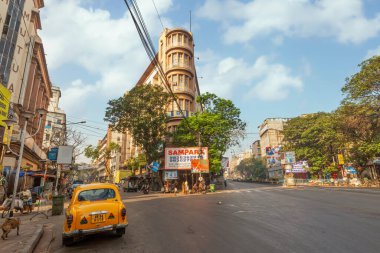 Kolkata, Hindistan, 14 Mart 2021: Taksi Kolkata, Hindistan 'daki Chandni Chowk bölgesinde eski ofis binaları manzaralı şehir yoluna park etti