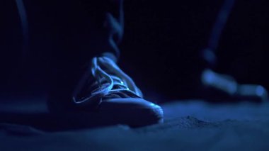 Feet of guitar player in blu light and slow motion