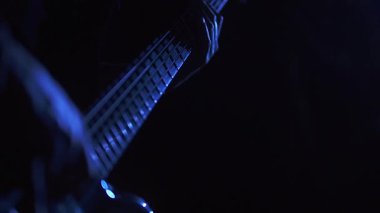 Bassist player performing in blue light and slow motion