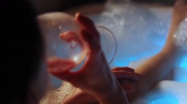 Kız jakuzide şarap içiyor.