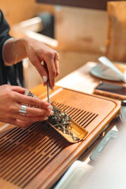 Geleneksel ahşap bir chahe 'de dinlenen gevşek çay yapraklarının yakın plan fotoğrafı sunum, aroma tatmini ve dikkatli çay hazırlama ritüelleri için kullanılan çay seremonisi aleti..