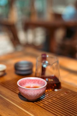 Geleneksel çay seremonilerinde kullanılan küçük seramik çay fincanının minimalist yakın çekimi, basitliği, dokuyu, işçiliği ve dikkatli çay içmenin sakin estetiğini vurgulamak..