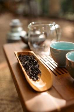 Geleneksel ahşap bir chahe 'de dinlenen gevşek çay yapraklarının yakın plan fotoğrafı sunum, aroma tatmini ve dikkatli çay hazırlama ritüelleri için kullanılan çay seremonisi aleti..