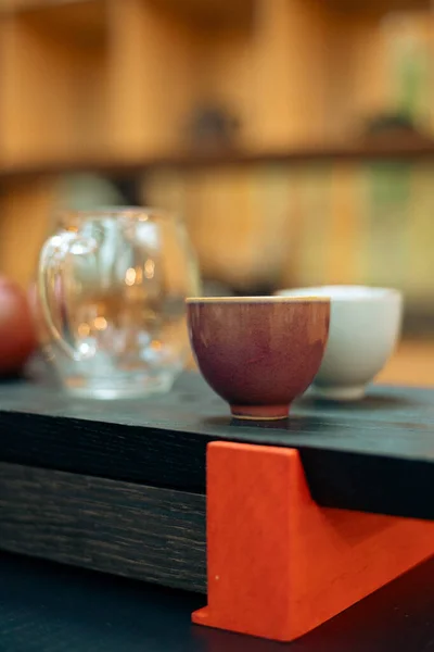 Geleneksel çay seremonilerinde kullanılan küçük seramik çay fincanının minimalist yakın çekimi, basitliği, dokuyu, işçiliği ve dikkatli çay içmenin sakin estetiğini vurgulamak..