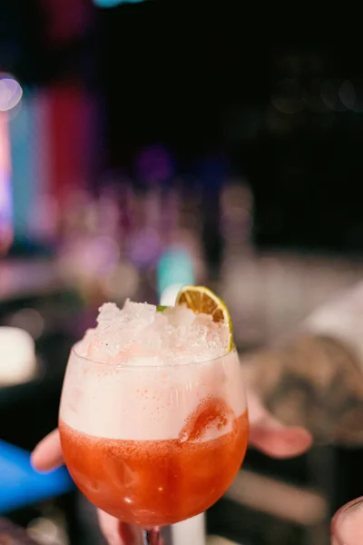 Gece hayatı, kokteyl kültürü ve konukseverlik kavramları için mükemmel köpük ve narenciye dolu kırmızı bir kokteylin yakın çekimi. Bar 'daki Stemed Glass' te Kırmızı Kokteyl.