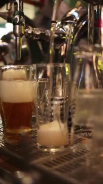 Taze bira ya da elma şarabı bardağa akarken barmen bir elin musluk kolunu çekerek otantik bar atmosferini ve profesyonel içki servisini yakaladığı yakın çekim videosu, 1080p 60 fps.