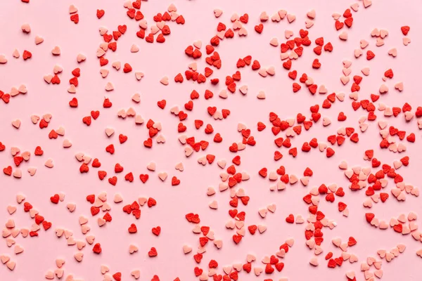 sprinkles background, sugar sprinkle red hearts, decoration for cake and bakery. Top view, flat lay. Valentines holiday.