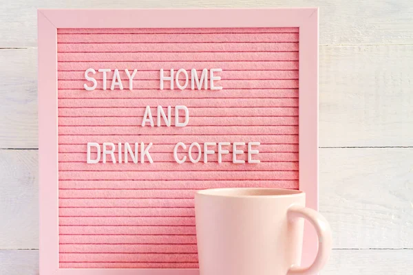 Pink Coffee cup and qoute Stay home and drink coffee. Self isolation and quarantine campaign to protect yourself and save lives.