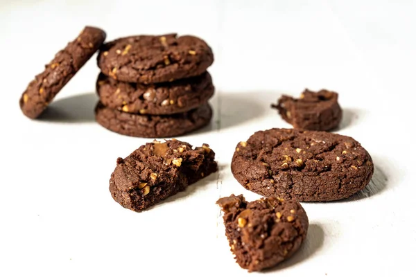 Stuck of Homemade american chocolate cookies with nuts on white wooden background. Fresh pastry
