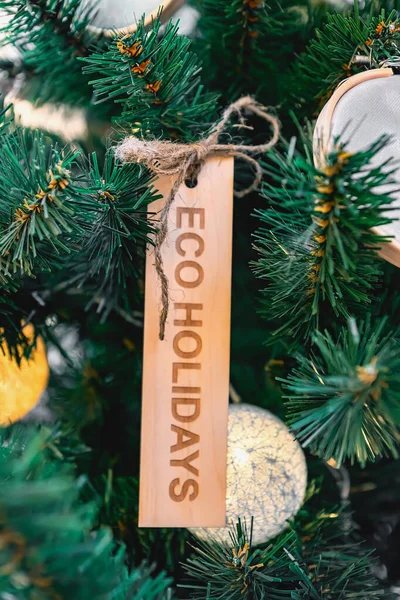 Zero waste eco-friendly christmas tree with wooden toy and text eco holidays. Environmental concept.