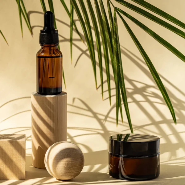Amber cosmetic bottles with pipette on wooden geometric pedestal podiums, product packaging with natural palm leaves, anti aging serum with peptides, cosmetics mockup, spa concept