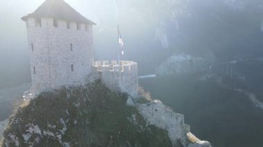 Üssünde panoramik şehir manzaralı tarihi bir tepe kalesinin nefes kesici insansız hava aracı yörüngesi videosu. Seyahat filmleri, tarihi belgeseller veya şehir tanıtım projeleri için ideal.