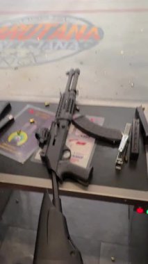 Belgrad, Sırbistan - 22 Ağustos 2025: Ateş etmeden önce uygun duruş, tutuş ve konsantrasyon sergileyen, kapalı alanda atış talimine hazırlanan bir kişinin odaklı videosu. 