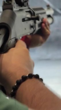 Bir av tüfeğinin atış poligonunda bir hedefe ateş edişinin dinamik yakın çekim videosu. Silahın güçlü hareketi, geri tepme, namludan çıkan patlama, ve kağıt hedefin üzerindeki etkisi....