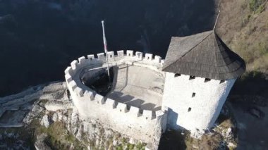 Bir İHA 'nın fırlatıldığı anı yakalayan ve antik bir tepe kalesinden hızla geri çekilen yakın çekim bir video. Dinamik bir ivme kazanmadan önce taş duvarların detaylı dokuları çevredeki manzarayı ortaya çıkarıyor..