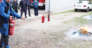 Belgrad, Sırbistan - 21 Ağustos 2025: Uygun bir yangın söndürme eğitimi gösterisi. Görüntüler, kontrollü bir ortamda PASS tekniğini uygulayan birinin kontrollü bir eğitim ateşinde kuru bir kimyasal yangın söndürücüyü boşalttığını gösteriyor..
