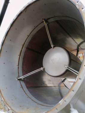 Geniş bir endüstriyel metal boru ya da havalandırma kanalı içinde, dairesel çelik yapısını ve mekanik desteklerini gösteren, mühendislik, inşaat ve ağır sanayi konseptini temsil eden yakın görüş.