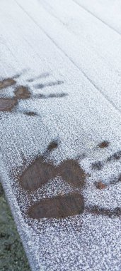 Handprint on a frosty surface with selective focus on the handprint