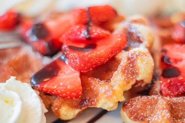 Çikolata soslu fırınlanmış Viyana waffle 'ında dilimlenmiş çilek.