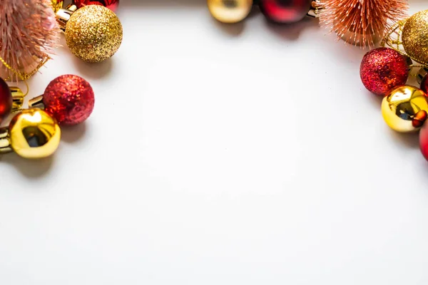 Yeni yıl kırmızı ve altın topları çerçevenin üst kısmında beyaz arkaplan üzerinde, yatay çekim alanı metin için