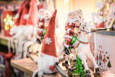Açık renkli tatil süslemeleri. Noel Baba 'nın at üstünde oturduğu bir raf.