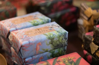 Bir mağaza rafında sunulabilir mavi ambalajlı el yapımı sabun.