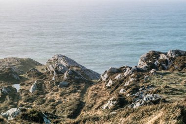 Atmosferik bir uçurum fotoğrafı yosun ve otla kaplı, uçurumun ötesinde deniz, Koyun Başı 'nda doğa, Batı Cork, İrlanda