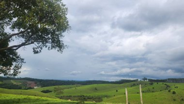 Brezilya 'da bir sığır çiftliğinde yeşil dağlar Dikenli tel örgülerle çevrili.