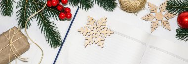 Noel için hediye paketliyorum. Yeni yıl arifesi için dilekleri ve dilekleri kaydetmek için boş bir defter aç. İp, geri dönüşümlü atıktan gelen çevre dostu kağıda sarılmış hediye paketi.