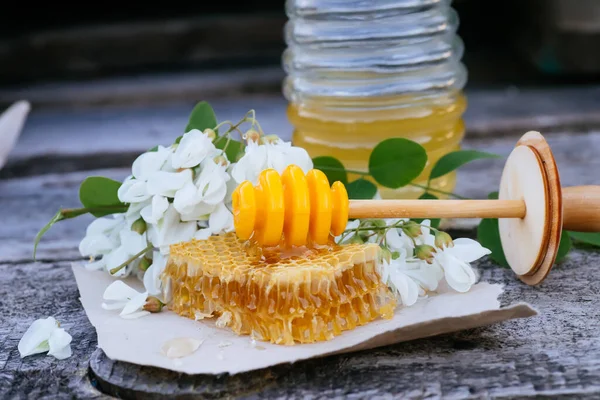 ハニーディッパー ハニースティックは ハニーコンズのカットオフ新鮮な蜂蜜の一部に位置しています 木製の背景に砂糖のアカシアの蜂蜜 春の気分 選択的焦点 — ストック写真