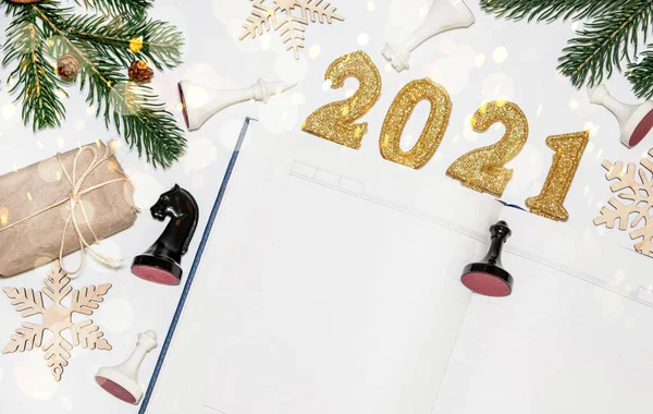 gifts for Christmas banner . Open blank notebook to record wishes and wish list for New Year\'s Eve, gift packaged in eco-friendly paper from recycled waste. chess pieces, a plan for a chess player\'s year
