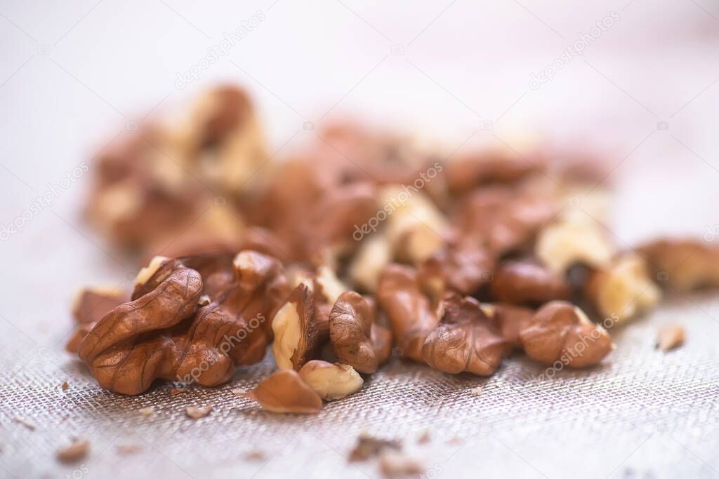 snouth of walnut kernels without peel is untreated on table. Ingredients for baking and pies. Soft focus. Blured picture.