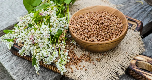 Ahşap tabakta kurutulmamış karabuğday. Çiğ yiyecekler ve vejetaryenler için yiyecek. Kilo vermek için sağlıklı yiyecekler. Yumuşak odak