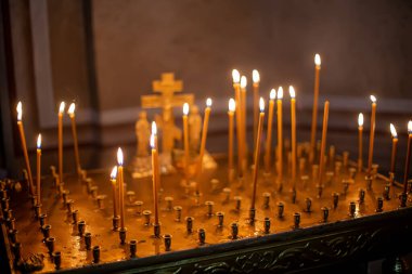Ortodoks kilisesindeki cenaze masasında dinlenmek için mumlar yakılıyor. Metal bir masada yemek servisi. İsa onu çarmıha gerdi. Yumuşak odak