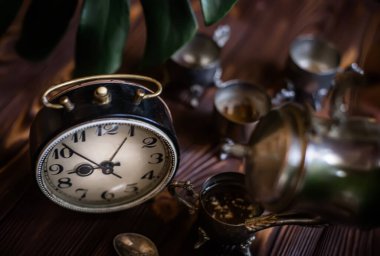 Kahvaltıda. Eski bir kahve demliğinden el yapımı kahve. Eski bir çalar saatin yanında gümüş bir kupa. Zaman doldu. Çok az zaman. Güneşin doğuşuyla aydınlanan bir masada gümüş mahsullü dama. İş günü için hazırlanılıyor.