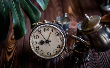 Retro saat. Eski usülde kahvaltı. Alarm saatinin yanındaki masada antika aletler