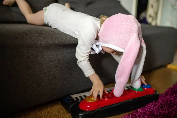 Niño Jugando Sintetizador Una Niña Acuesta Sofá Gris Toca Piano —  Fotos de Stock