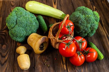 Taze sebzeler ve ahşap bir havanda biber karışımı. Organik çiftçi ürünleri. Brokoli, domates, marketten salatalık. Uygun beslenme konsepti. Sağlıklı yemek.